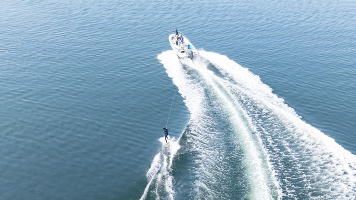 Two boats leaving a trail of white water on a blue body of water